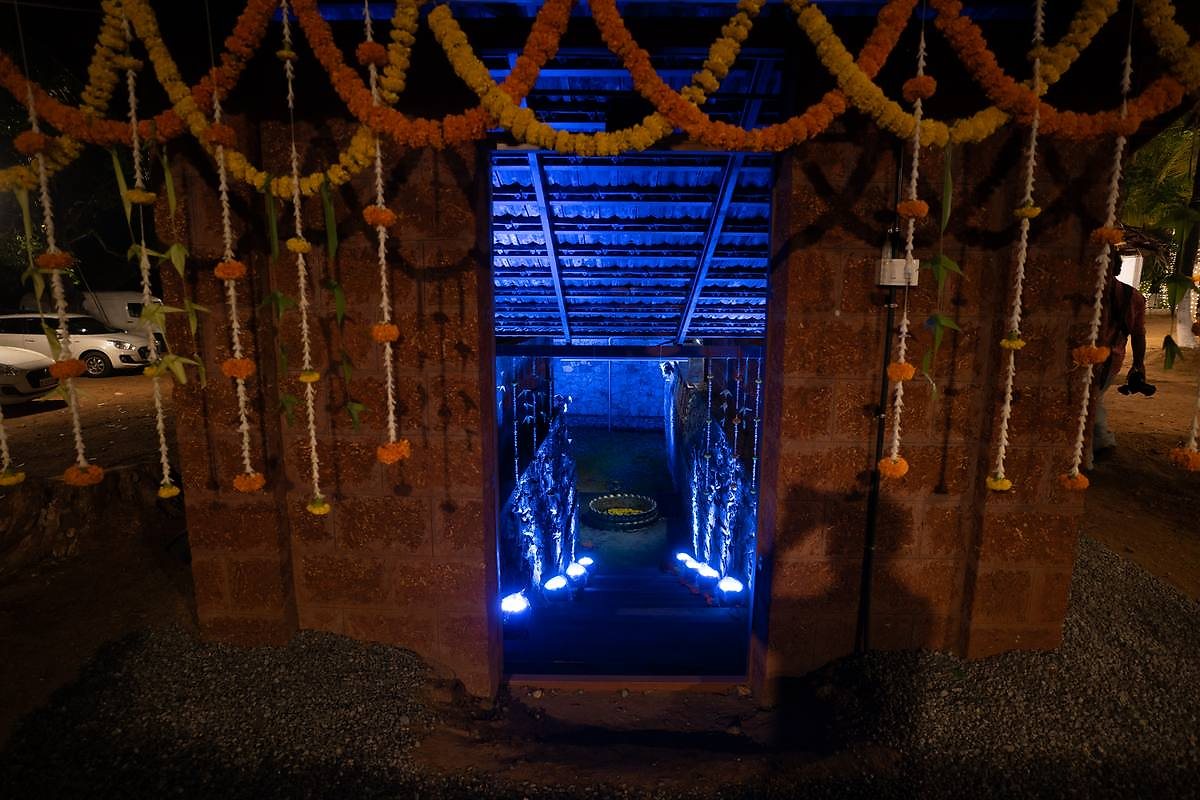 Pond entrance at night, framed by marigold garlands and blue lights