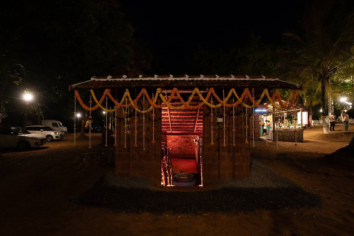 Traditional shrine set-up glowing under marigold garlands at night